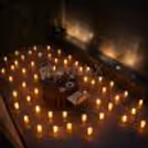 Close up of floral centre piece on a proposal dinner table with a warm candlelight atmosphere.