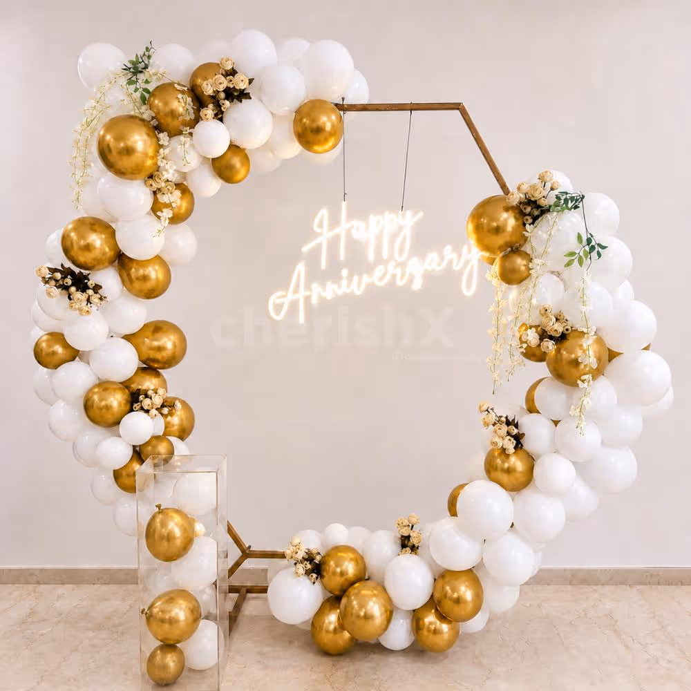 CherishX anniversary decor with premium gold and white balloons, floral accents, and glowing Happy Anniversary neon.