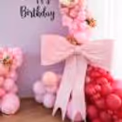 White and pink rose flower bunches add a realistic appeal to the birthday balloon decor.