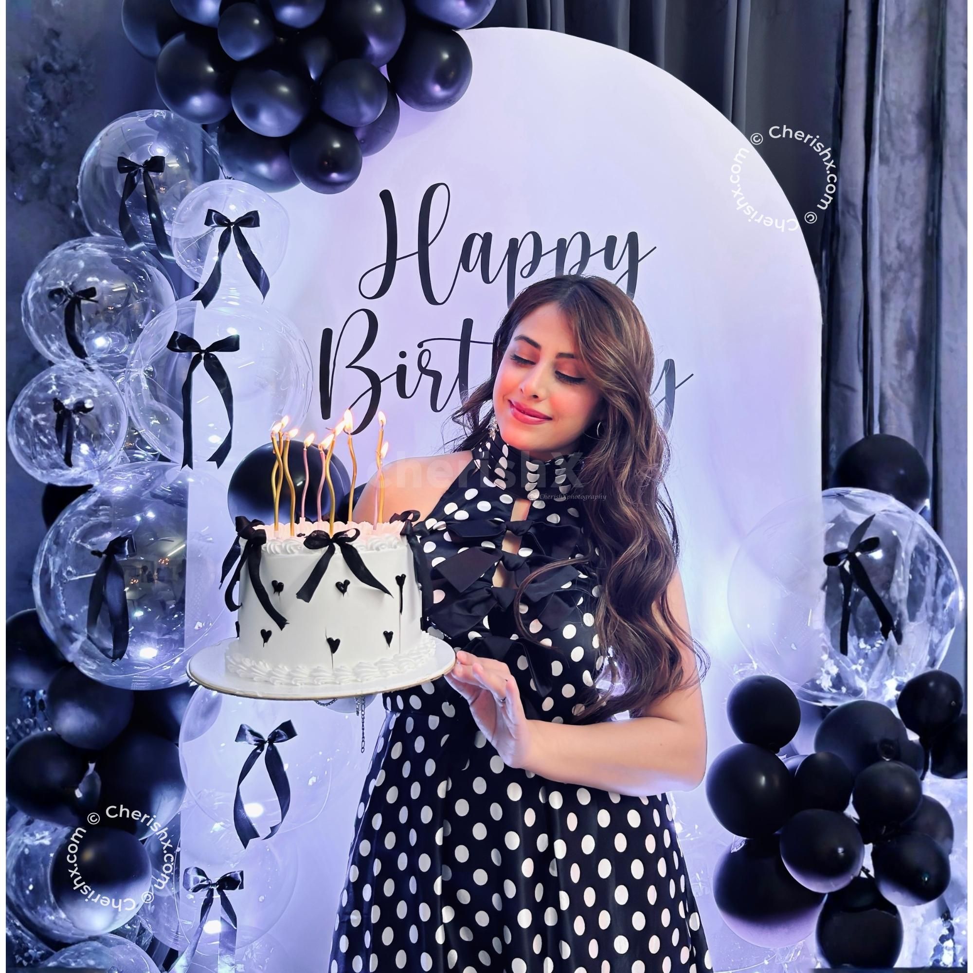 Latex black balloons reflect the light, adding depth and a modern texture to the birthday decor