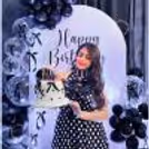 Latex black balloons reflect the light, adding depth and a modern texture to the birthday decor