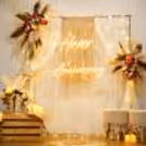 Boho anniversary setup with pampas grass, florals and soft lighting.