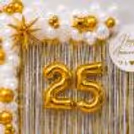 White and gold balloon arch design with golden star decorations for an anniversary party.