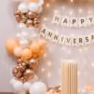 Number balloons of rose gold foil around the anniversary backdrop.