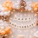 Warm fairy lights with a Happy Anniversary banner set a festive backdrop.