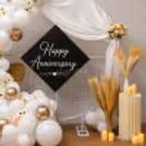 Elegant white balloon, flower, candle, and pampas grass decoration for an anniversary
