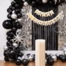 Amazing metallic anniversary balloon decoration, silver star foil balloons and black balloon garland make the perfect elegant celebration display.