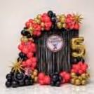 Flash birthday background with red, black and gold balloon decorations.