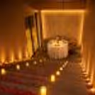 Celebrate love with a premium candlelight dining experience by CherishX, featuring a romantic stairway, rose petals, warm lights, and a cozy private dinner table.