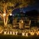 picture-perfect proposal setting featuring a sea of white blooms and a magical candlelit atmosphere