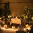 Romantic private dining arrangement, lighted planters, comfortable seating and soothing soft lighting.