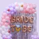 For a bride-to-be event, decorate with a pastel pink, lavender and white balloon arch with chrome balloon accents.