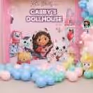 Pink Fringe Curtains, Pastel Balloons And Cute Character Cutouts Theme Setup For Gabby's Dollhouse.