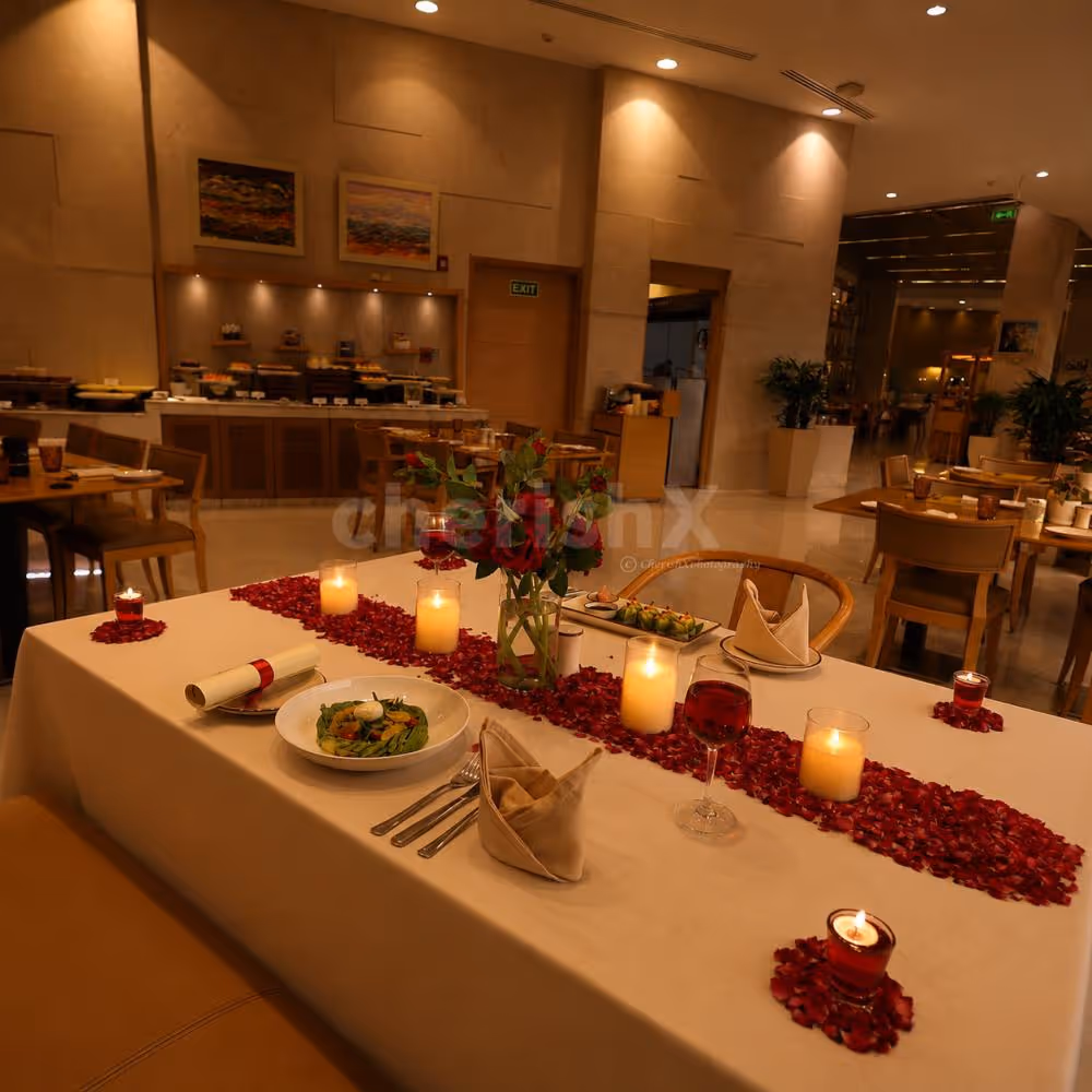 Romantic candlelight dinner setup with rose petals and elegant table décor at a luxury hotel restaurant
