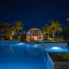 Private couple dining experience beside a beautifully illuminated swimming pool.