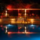 Table near pool with candlelight, elegant pool table decoration and lighting with glowing candles next to the swimming pool.