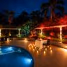 A romantic candle-light dinner scene, with a well-set table by the pool.