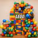 Birthday Backdrop With Lego Characters And Colourful Balloons.