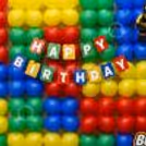 The Happy Birthday Lettering Is Set Above A Graphic Toy Building Block Style Decoration.