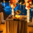 Outdoor candlelit dining experience with illuminated balloon arch and luxury event styling.