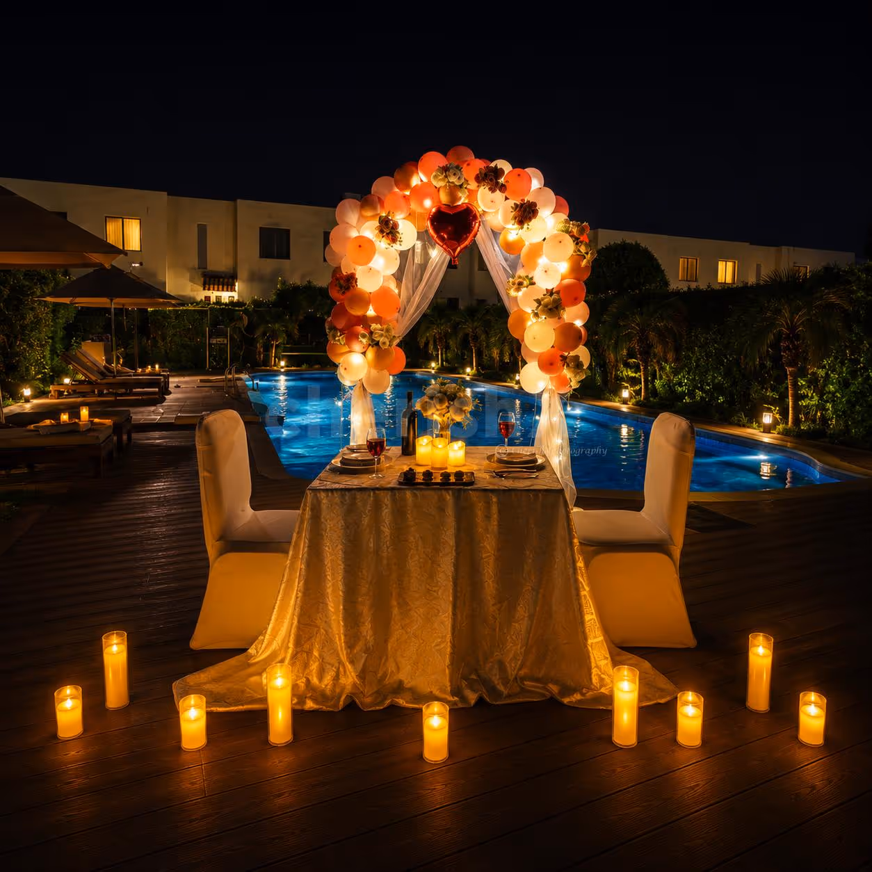 Private poolside dining setup with candles, floral decorations, and romantic evening ambiance.