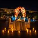 Private poolside dining setup with candles, floral decorations, and romantic evening ambiance.