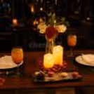 Elegant couple dining setup with candles, flowers, mocktails, and romantic restaurant décor for anniversaries and special celebrations.