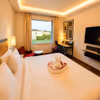 Spacious hotel room with king-size bed, warm lighting, modern interiors, and garden views, perfect for a relaxing daycation.
