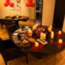 Romantic dinner with two seating arrangements, chairs and balloons.