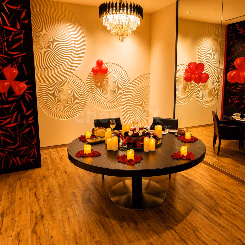 Private fine-dining setup with elegant tableware, appetizers, candlelight décor, and romantic floral arrangements for couples.