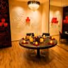 Elegant private dining space with chandelier and round dining table and warm indoor lighting.