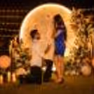 Romantic couple having luxury candlelight dinner with flower moon decoration.