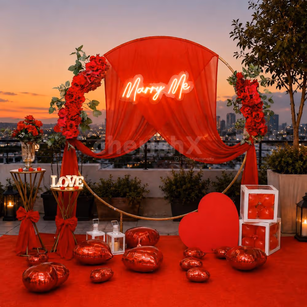 Love is in every detail. From the red floral arch to the candlelit tables and balloon boxes, this CherishX rooftop proposal decor is designed to make your special moment unforgettable.
