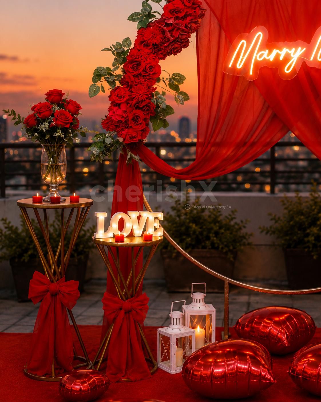 Make your proposal feel straight out of a romantic movie with CherishX. A red-themed rooftop Marry Me setup with flowers, candles, balloon boxes and premium decor details.