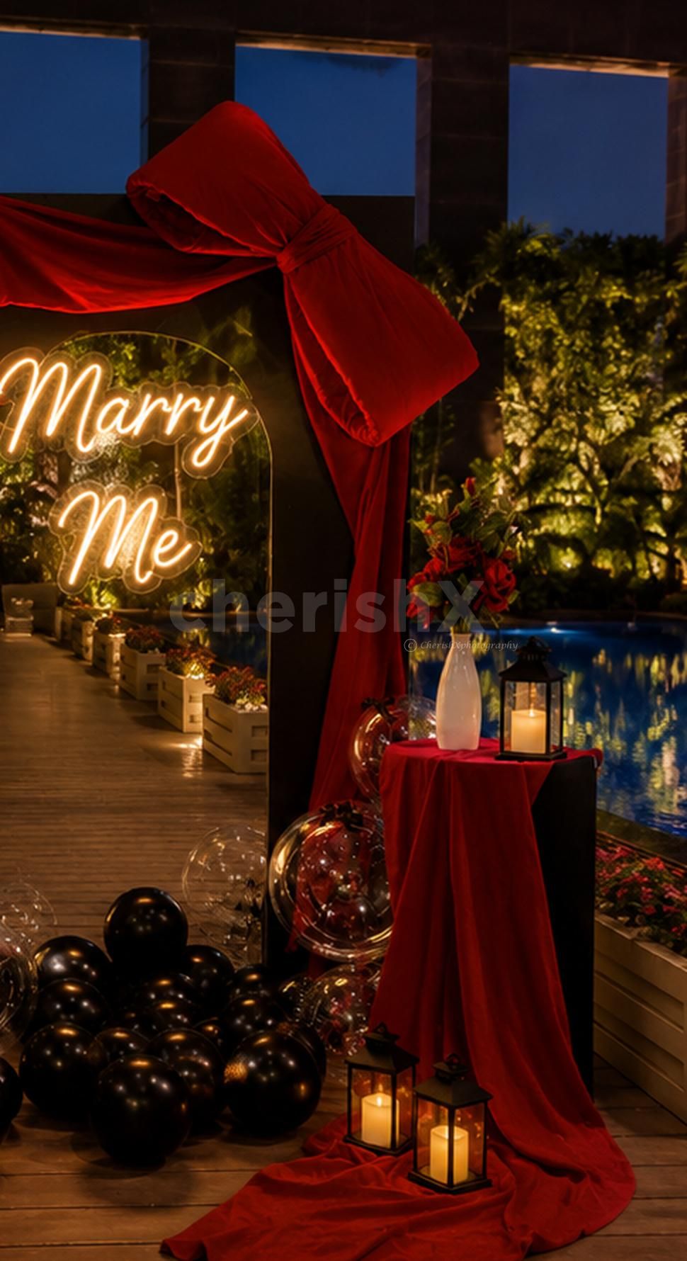 A picture-perfect proposal decor setup by CherishX featuring roses, balloons, lanterns, and a glowing neon sign.