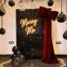 CherishX’s premium Marry Me decor setup featuring a black sequin panel, red velvet bow, warm lights, and elegant hanging balloons