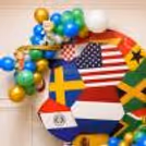 Circular Football Birthday Backdrop with International Flags, Balloon Clusters and Soccer Ball Props.