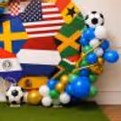 A football birthday decoration backdrop with blue, green, white and golden ball accents.