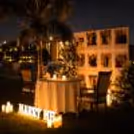 Personalized candlelight proposal dinner, photo wall, flower arrangement, and romantic outdoor dinner.