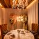 A beautiful cabana table with flower arrangements and great candles on the table for love birds.