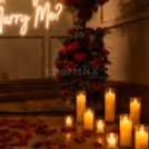 Led Candles Surrounded The Setup. Rose Petals Covered The Wooden Floor.