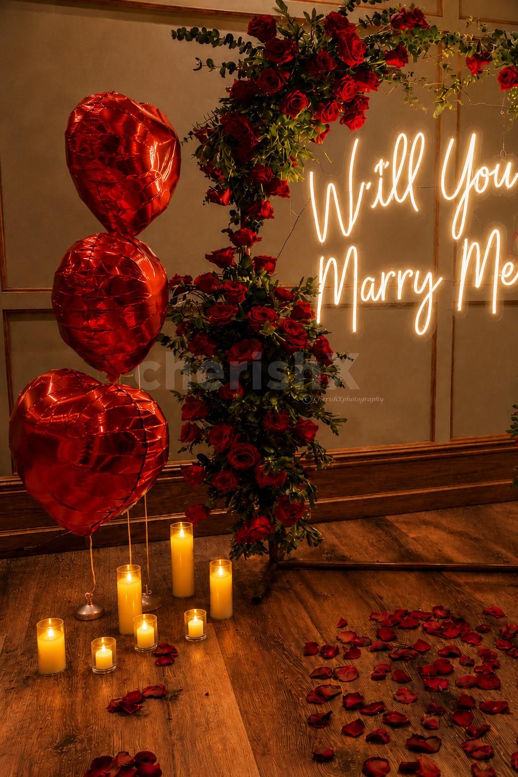 Red Heart-Shaped Balloons Were Next To The Flower Arch And Proposal Wall.