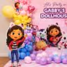 Pink, blue, purple and yellow balloon-decorated large standee character dollhouse for kid's birthday party.