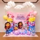 Pastel balloon arch, character standees and hanging cloud balloons themed around Gabby's Dollhouse for her birthday.