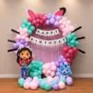Gabby's Dollhouse ring birthday decor with pastel pink, mint green, purple and rose balloon arch on a circle frame.