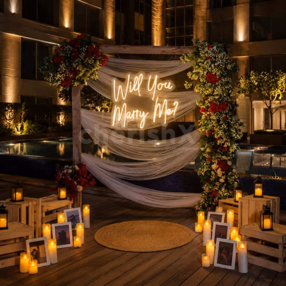 Luxury poolside proposal setup with romantic candlelight décor, flower petals, and private dining arrangement for couples.