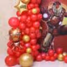 Iron Man birthday decoration with superhero backdrop and red gold balloons.