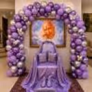 Devotional Seating Area Lined With A Lavender Balloon Arch With Silver Butterfly Accents Above A Spiritual Portrait In A Frame.