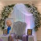 Silver curtains, spiritual seating, framed images, rose petals for Guru Ji Darshan.