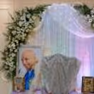 Decoration of Guru Ji with a floral arch, side tables, framed portraits and decorative lanterns by the ceremonial chair.